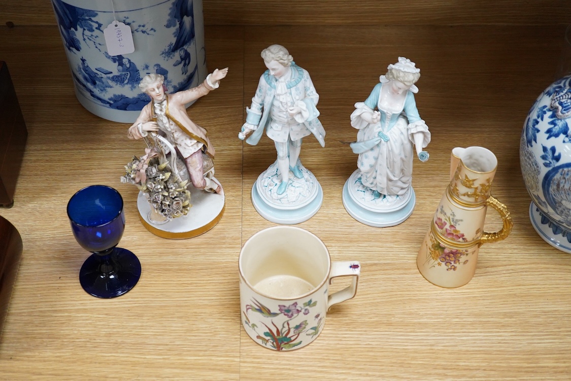 Sundry porcelain comprising three German figures, a Royal Worcester blush ivory ewer and a mug, together with a blue wine glass, largest 26cm high